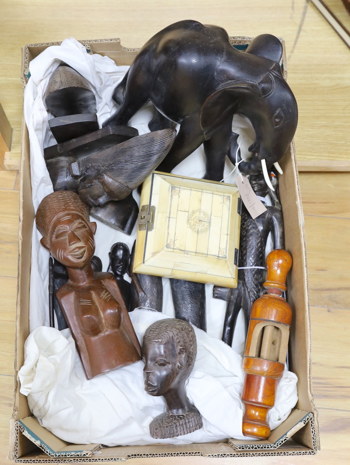 A collection of African tribal carvings, South East Asian bell frames and sundries